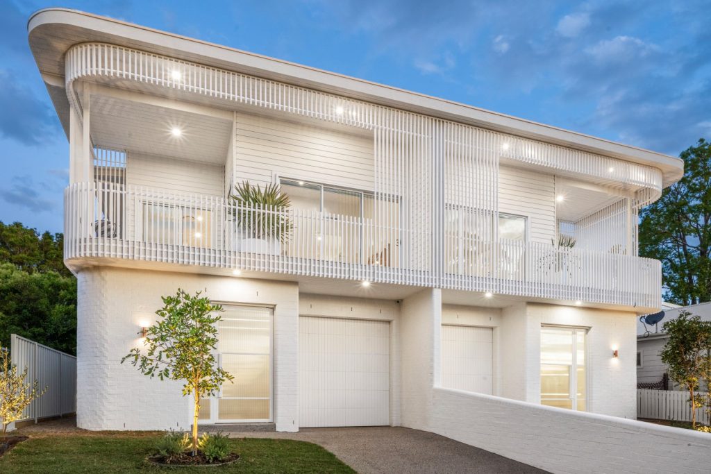 Facade lighting with wall-mounted uplights at dusk